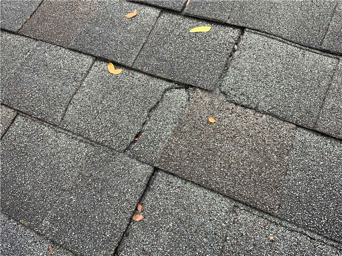 cracked-roof-shingle-asphalt-roofing-damaged-roof