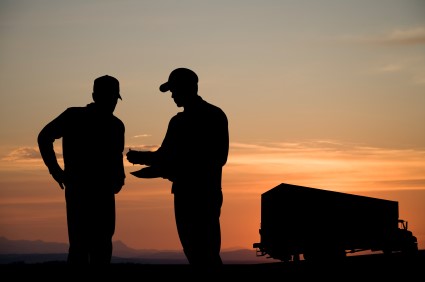 Silhouette of mover and customer talking in front of a moving truck