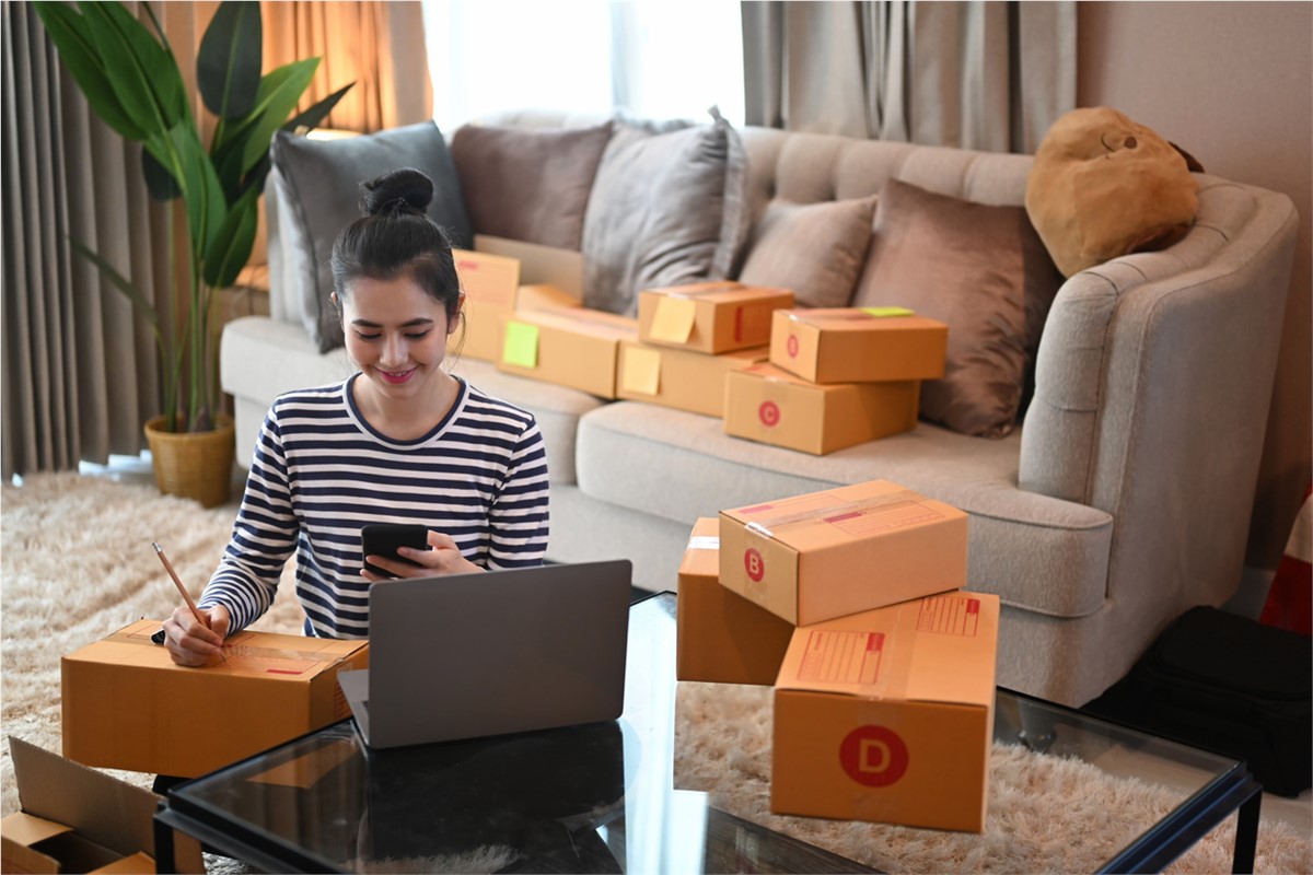 Person on a smart phone surrounded by moving boxes