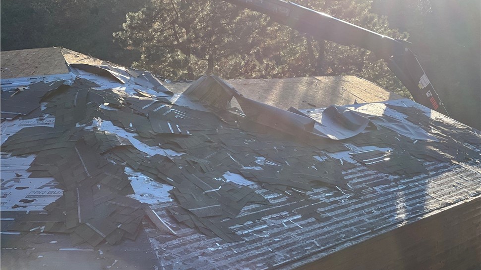 Roofing crew preparing roof for replacement in Rapid City, SD using GAF HDZ materials.