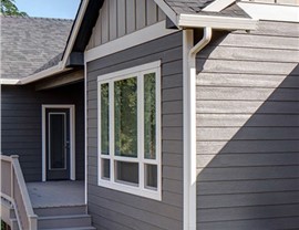 exterior of a home with gray siding and shite trim pieces