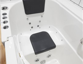 The interior of a walk-in bathtub shower water jets
