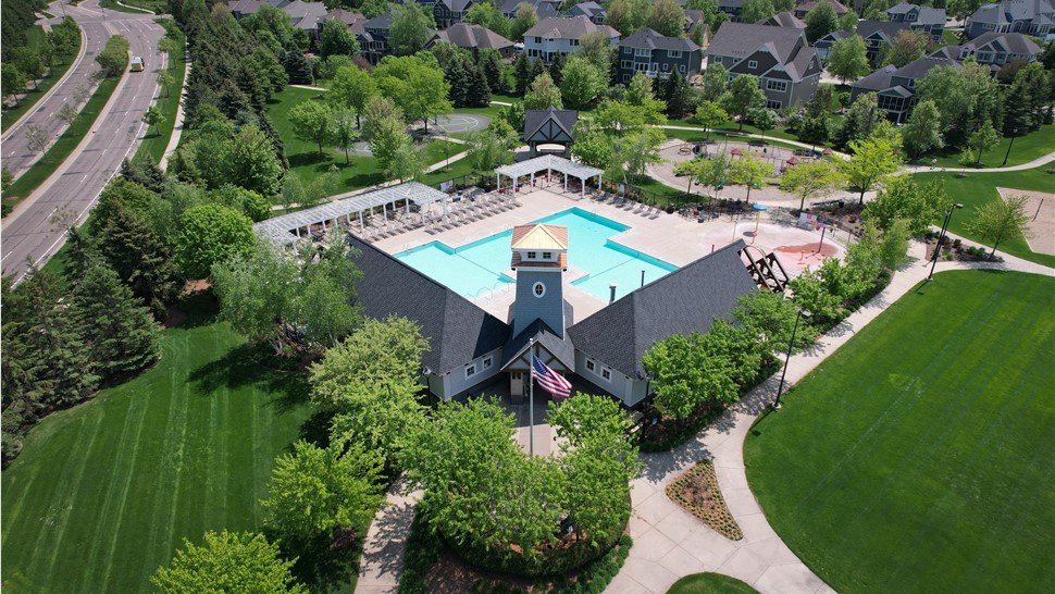 drone image of pool house or entrance to neighborhood pool with suburban neighborhood behind the pool