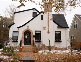 stucco white home with black roof and windows and front door