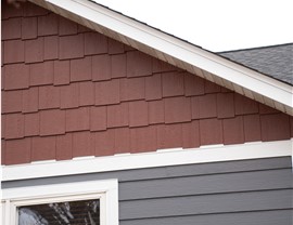 Close up of LP SmartSide Lap Siding in Cavern Steel vs. LP SmartSide Shakes in the color Redwood