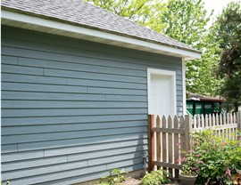 light blue siding on the side of a garage with white door at the counter
