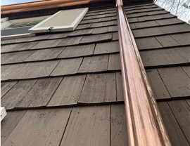 close up of wood shake siding and copper gutters