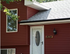 close up of red vinyl siding on one story home