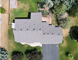 drone image directly above gray roof with red and blue speckles