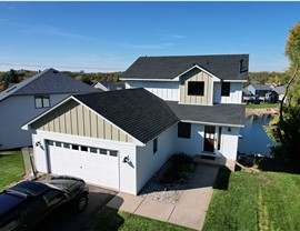 drone image of two story home with white and tan modern farmhouse siding