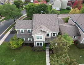 drone image of two story home with yellow and gray siding