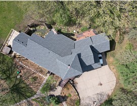 brown home with unique roof line, drone image sowing the home makes an L shape