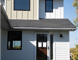 modern farmhouse renovation with white and tan siding and black windows