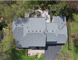 drone image of home directly above, the roof forms a rectangle filled with gray roof shingles