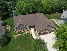 drone image of brown one story home with brown roof