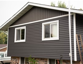 close up of a gable with dark gray siding with dark brown siding in the gable