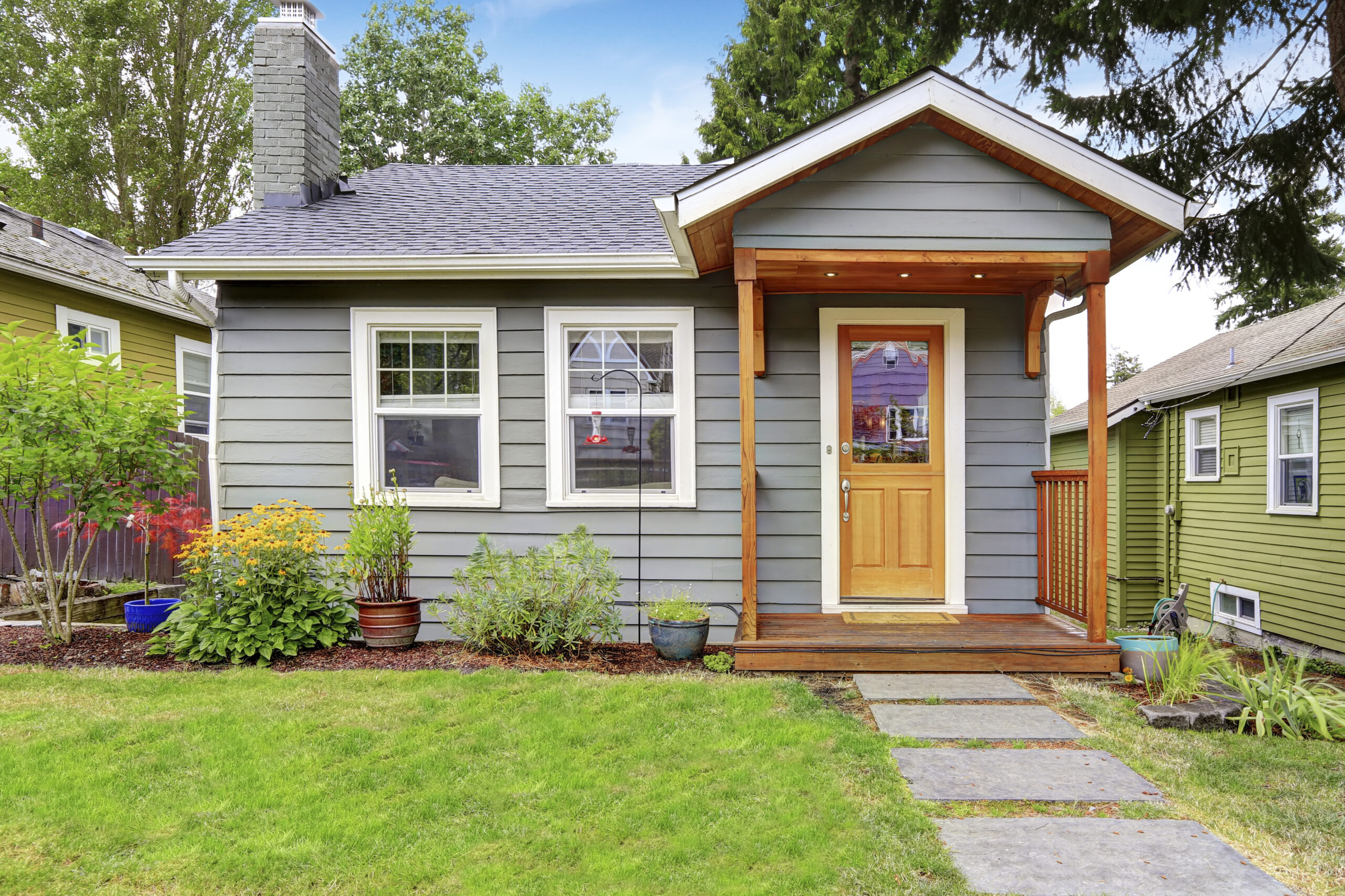 small grey craftsman house with natural wood entryway