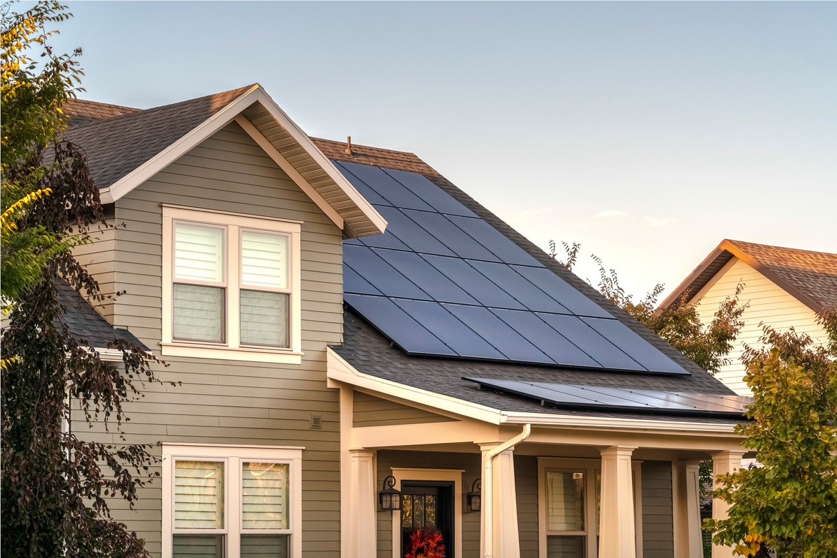 Putty colored Raleigh home with solar panels on top. 