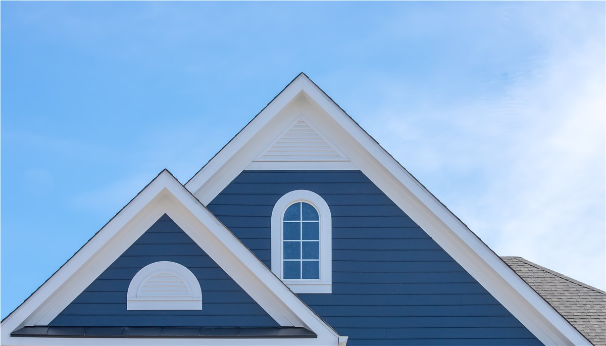 A gable vent on a blue home.