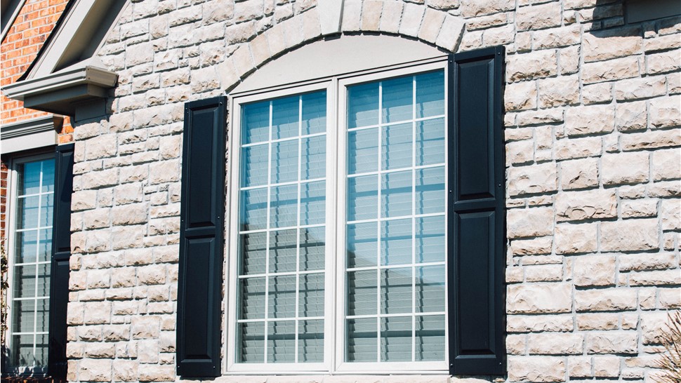 A newly installed window with black shutters