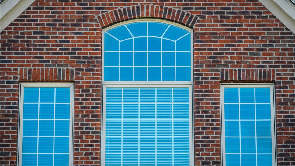 Massive windows on the brick exterior wall of a home
