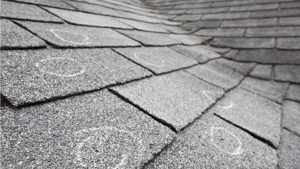 Hail damage on a roof is circled in chalk
