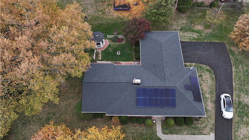 Aerial view of a house with a Charcoal Timberline HDZ shingle roof and solar panels in Canal Winchester, Ohio, surrounded by autumn trees and a gazebo.