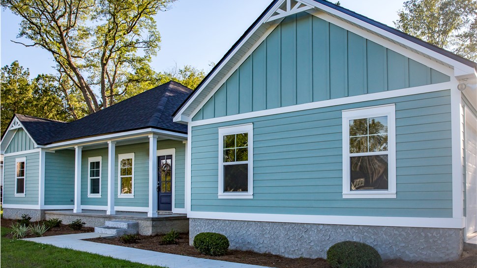 A blue home with new blue siding and windows with white trim