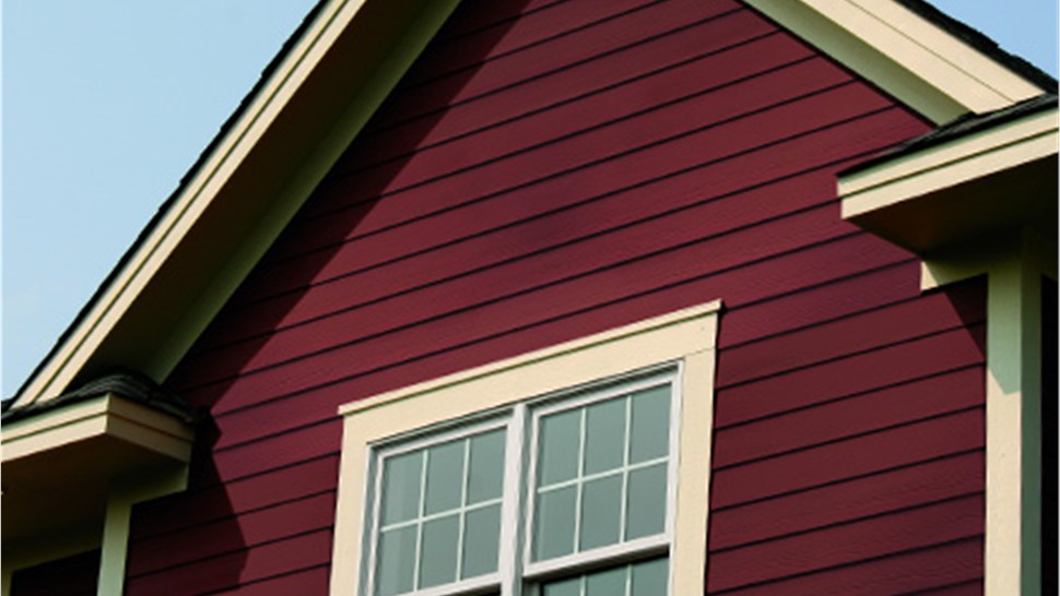 An exterior shot of a home with red vinyl siding
