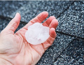A man holds a large piece of hail