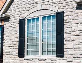 A newly installed window with black shutters