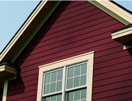 An exterior shot of a home with red vinyl siding