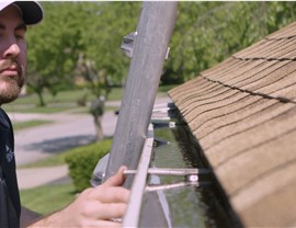 A man installs new gutters