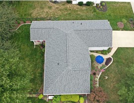 Drone view of a roof replacement in Newark, OH featuring Nantucket Morning Timberline HDZ shingles from GAF. The property includes well-kept landscaping and mature trees in the backyard, offering ample shade.