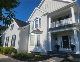 White two-story home in Mason, OH with new Charcoal GAF Timberline HDZ shingles installed during a roof replacement.
