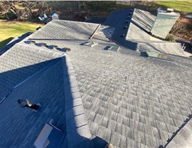 Close-up view of a newly installed Charcoal Timberline HDZ shingle roof in Indian Hill, Ohio, featuring multiple ridges, skylights, and venting systems for improved ventilation and durability.