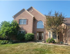 Two-story brick house in Mason, OH with new Barkwood Timberline HDZ shingles installed during a roof replacement.
