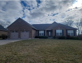 A newly installed Weathered Wood Timberline HDZ shingle roof on a brick home in Middletown, Ohio, under a partly cloudy sky.