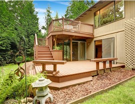 Multi-level wood deck with stairs and stone landscaping on home