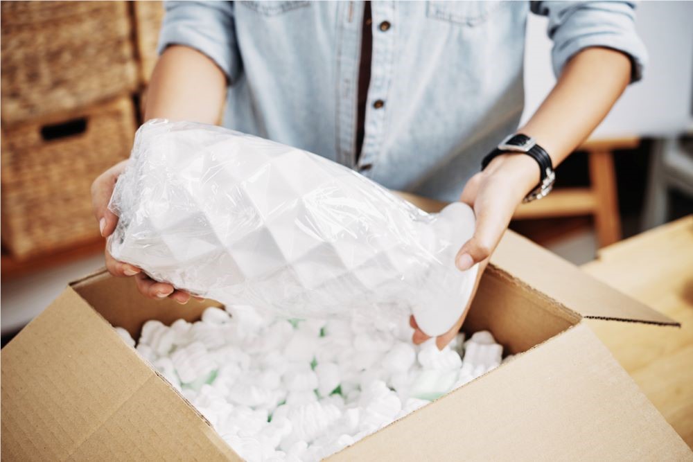 placing an item in a box with packing material