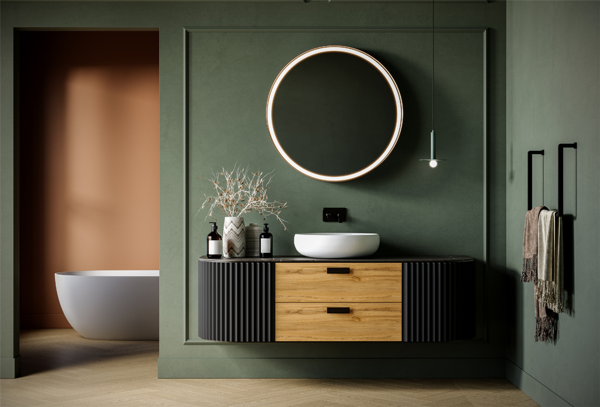 Elegant dark green bathroom with a floating fluted vanity, warm wood drawers, white vessel sink, round backlit mirror, and a glimpse of a freestanding soaking tub in an adjacent terra cotta room