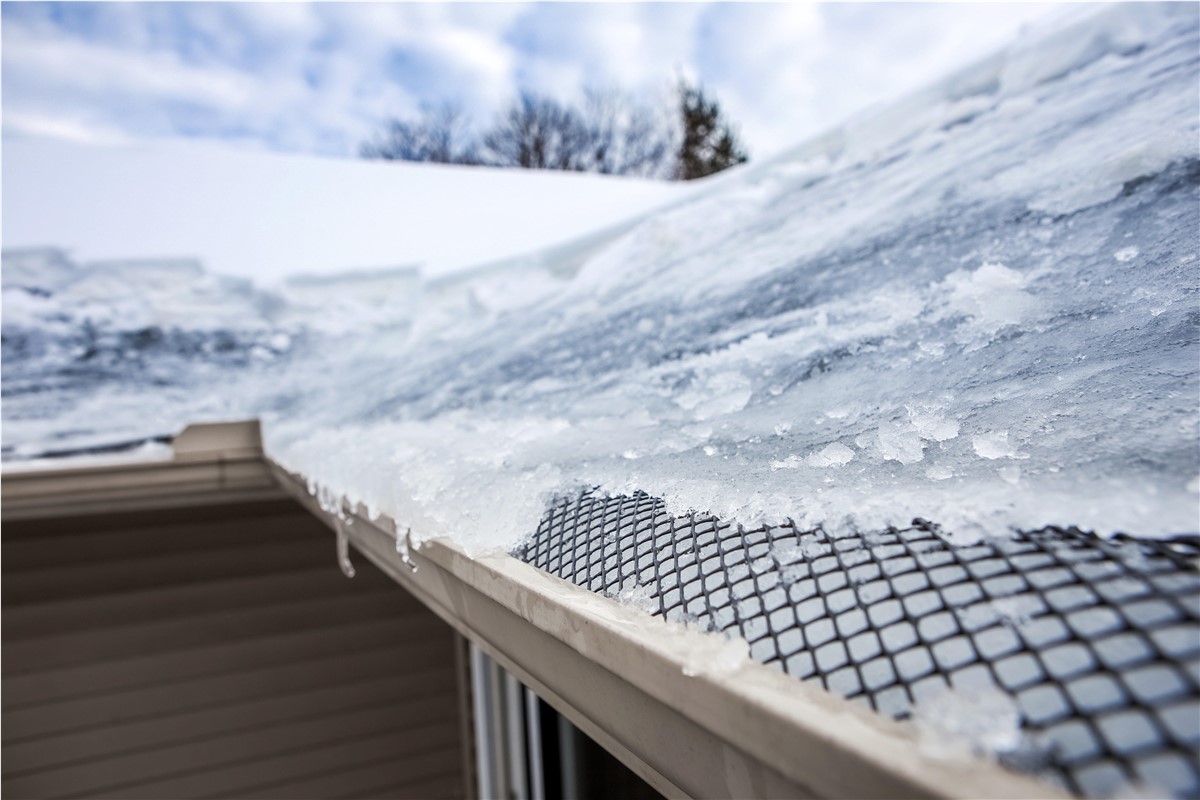 The start of an ice dam forming with ice blocking the gutters.
