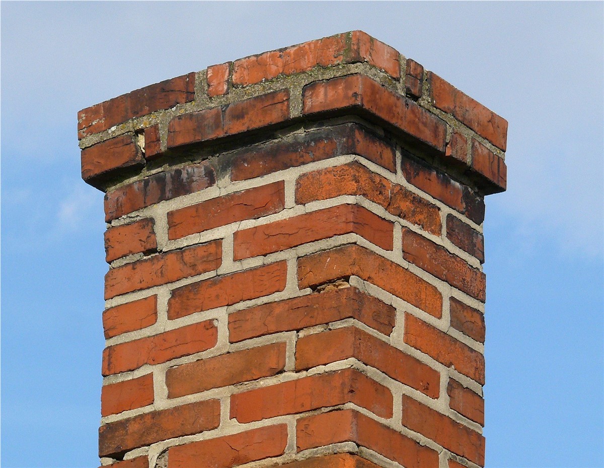 A chimney with missing mortar and no cap. 