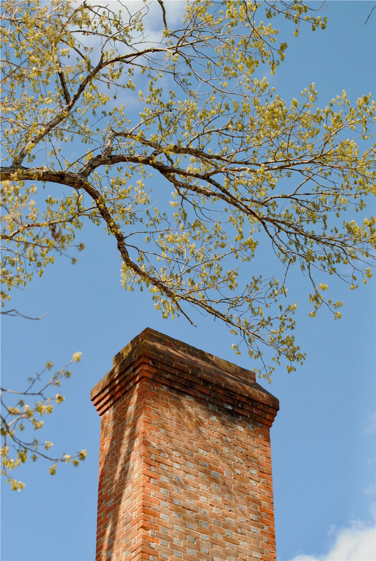A brick chimney against a blue sky. 