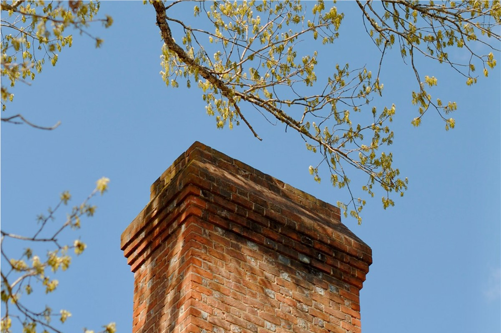 A brick chimney against a blue sky. 