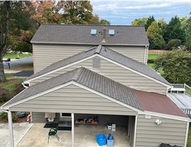 New Barkwood Timberline HDZ shingles on a Rockville, MD home with a multi-section roof, carport, and autumn trees in the background.