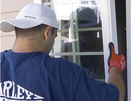 A Harley Exteriors window and door installer insert a custom-fit window into the frame.