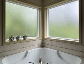 2 energy-efficient windows with obscure glass installed in a bathroom above the bathtub.