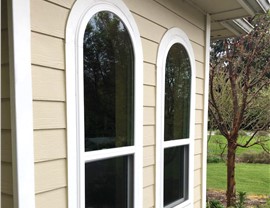 2 double hung windows with rounded tops that are energy-efficient and were installed by Harley Exteriors.