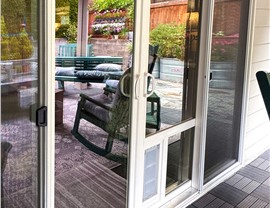 A sliding patio door with a built-in dog door.